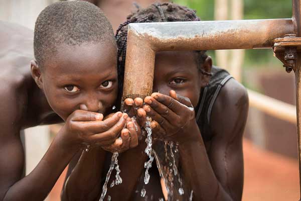 Kinder trinken aus Brunnen Afrika